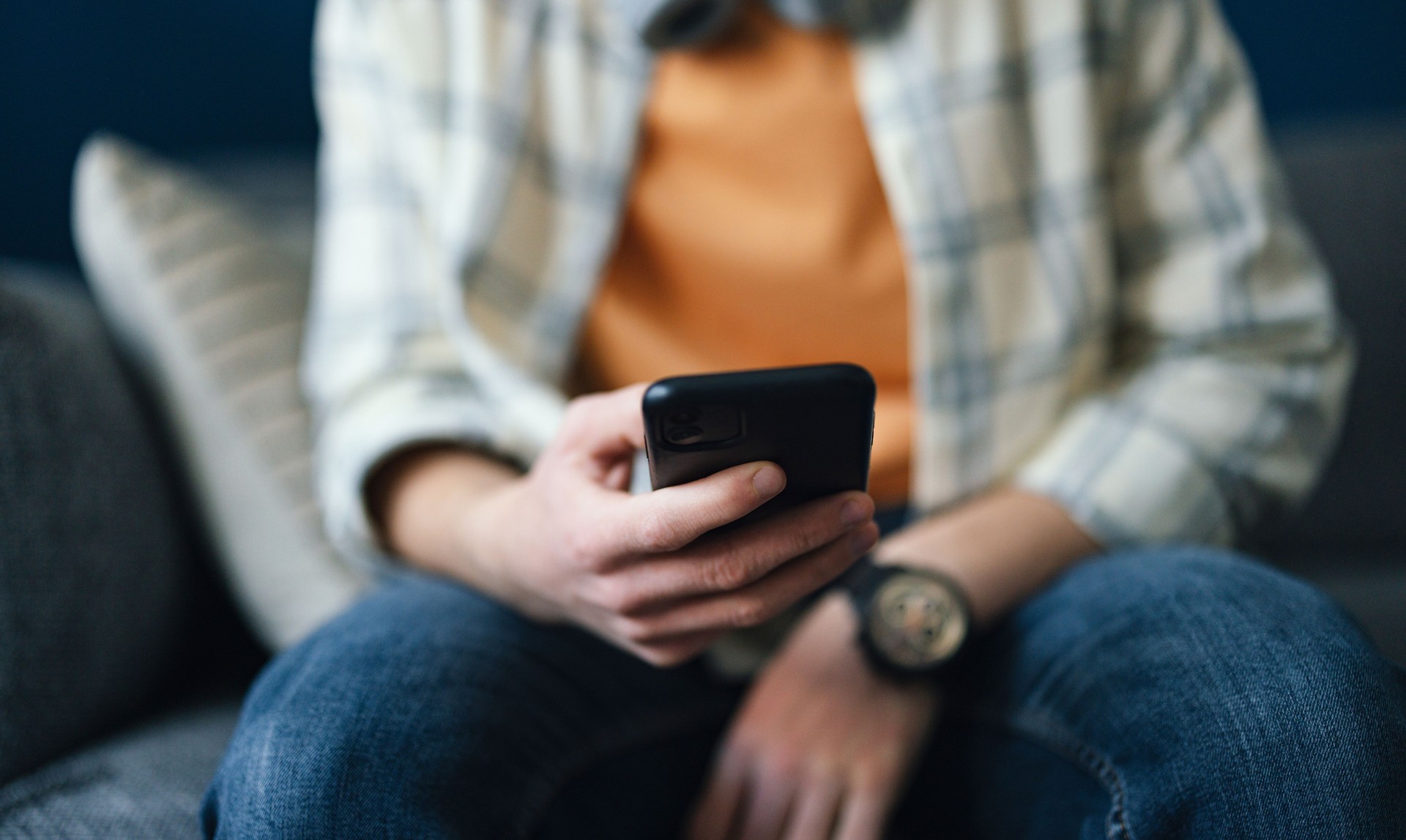 Anonymous Man Sitting and Using His Mobile Phone