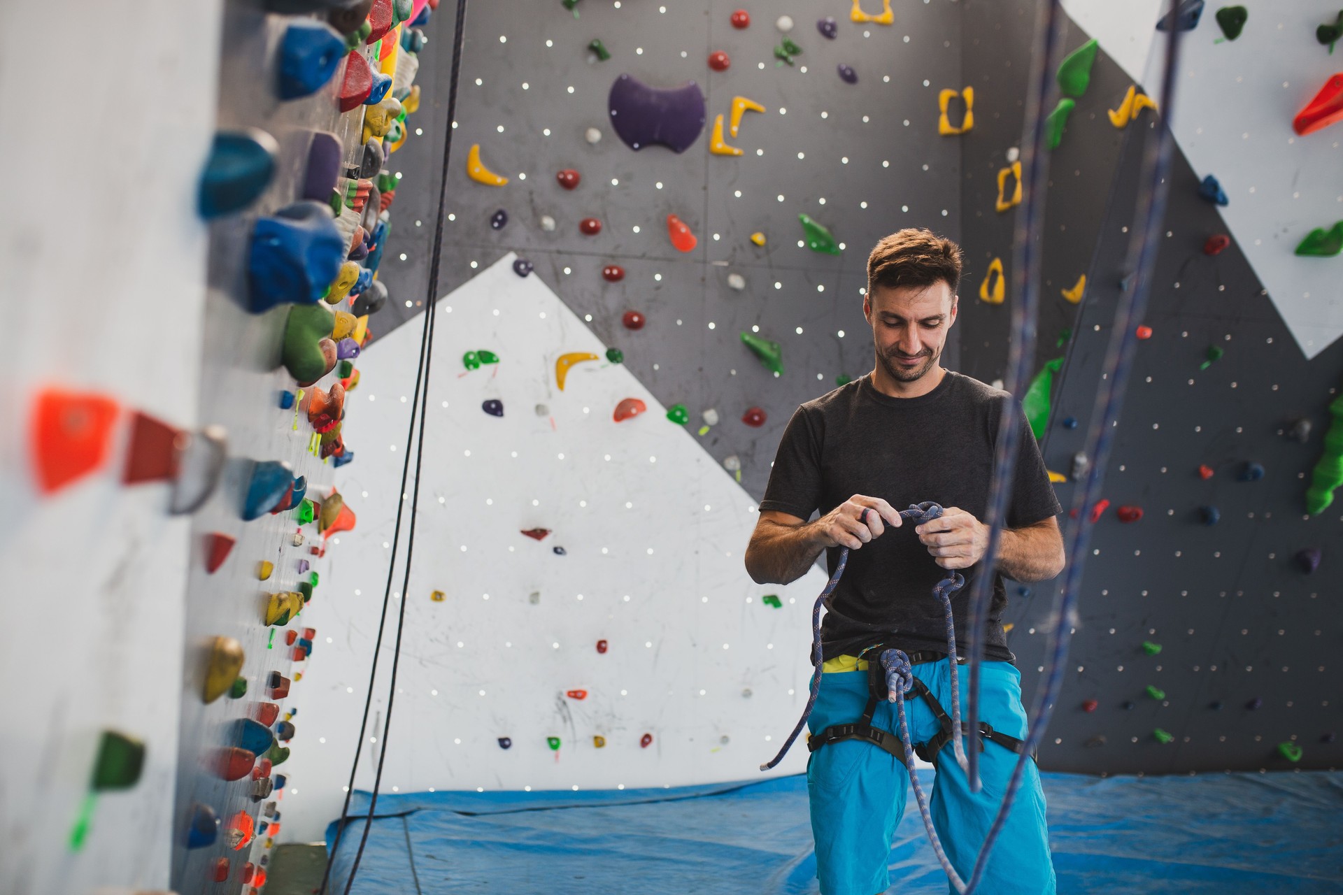 Athletic man climbing indoor wall.